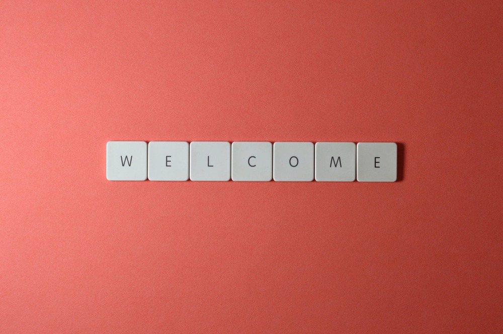 individual wood blocks placed together to create the word welcome on a salmon background